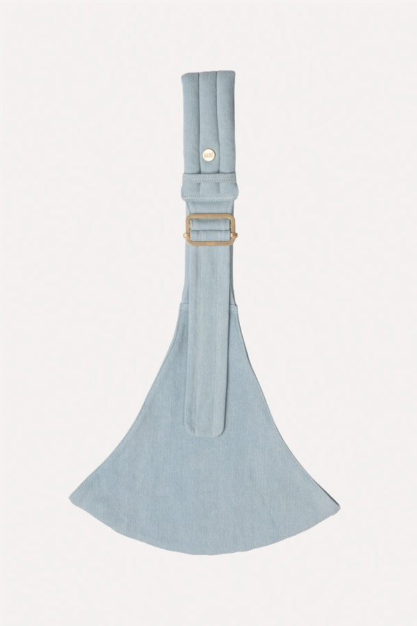 Light blue denim Mabē toddler sling with a strap laying flat on a white background