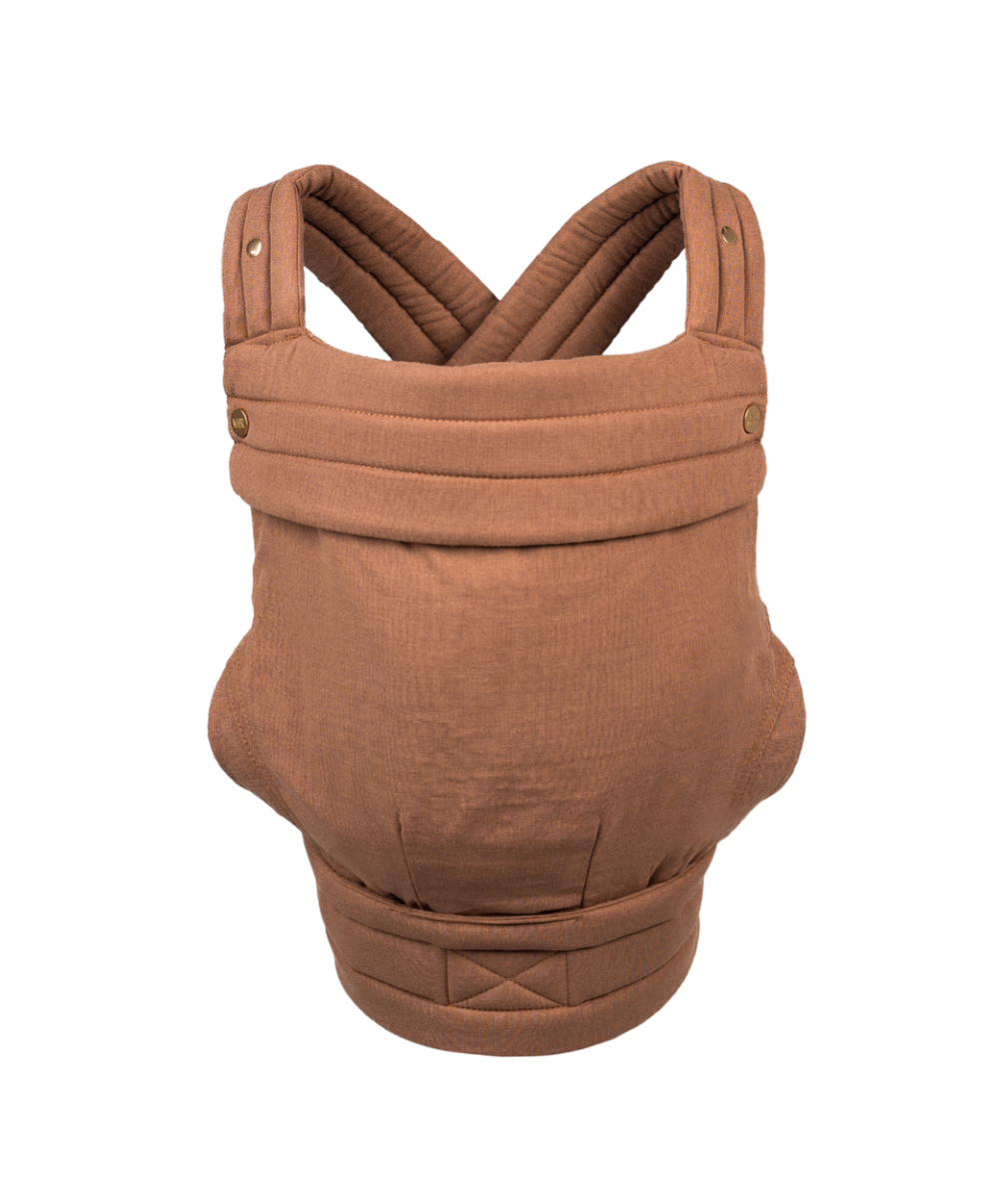 The Mabē Monarch Carrier, front view, alone on a white background. The carrier has crossed straps for across the back and a fold-down head support flap with snaps. This colorway is Mocha, which is solid medium pinky-brown.