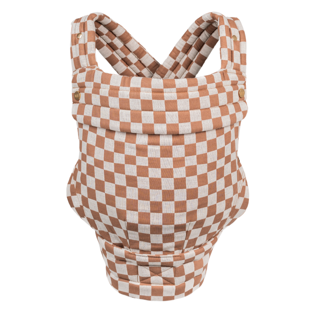 The Mabē Monarch Carrier, front view, alone on a white background. The carrier has crossed straps for across the back and a fold-down head support flap with snaps. This colorway is Mocha Check, which is checkered white aned medium pinky-brown.
